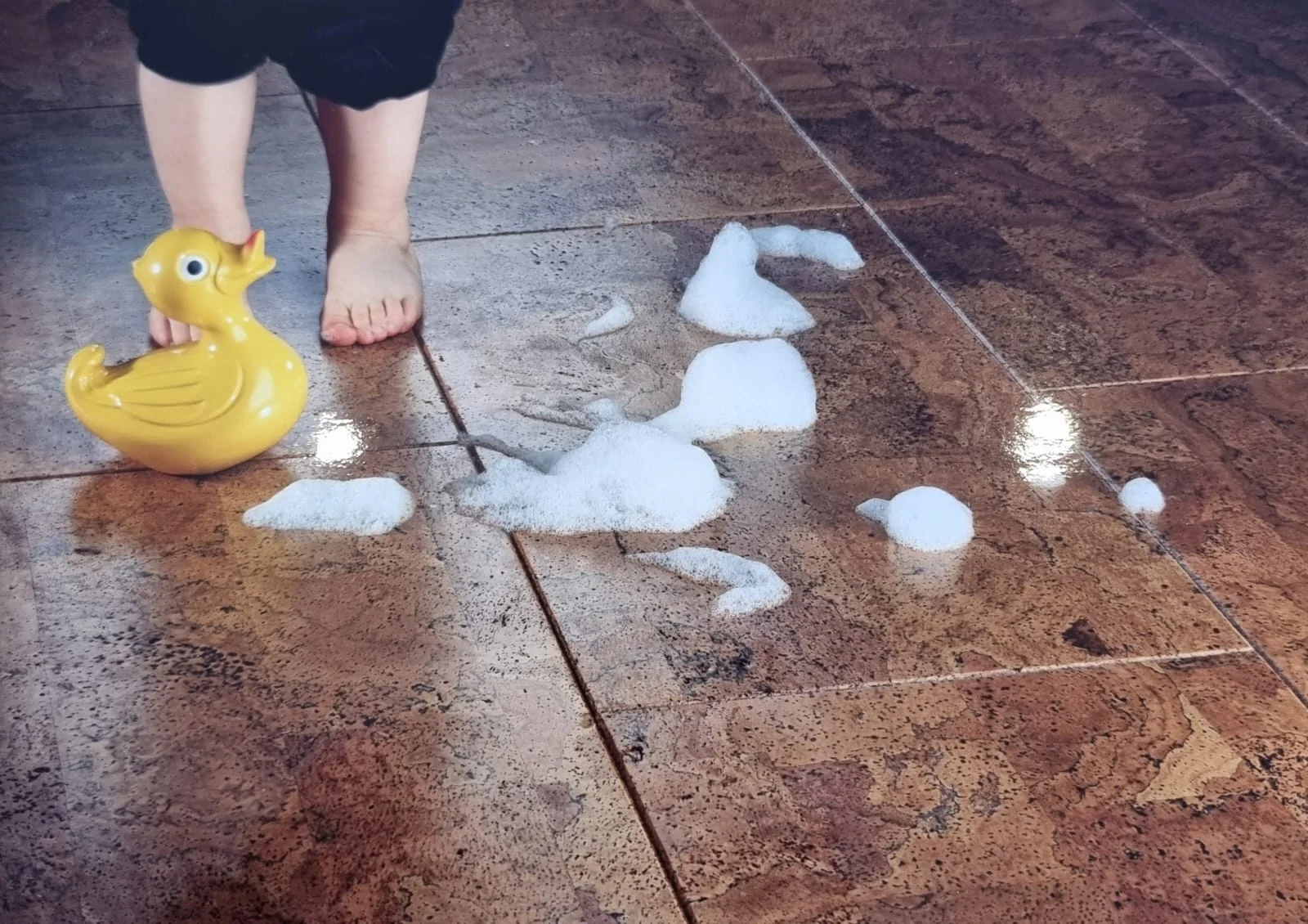 Kind auf Korkfliesen im Badezimmer – Stony Kork in Fliesenoptik